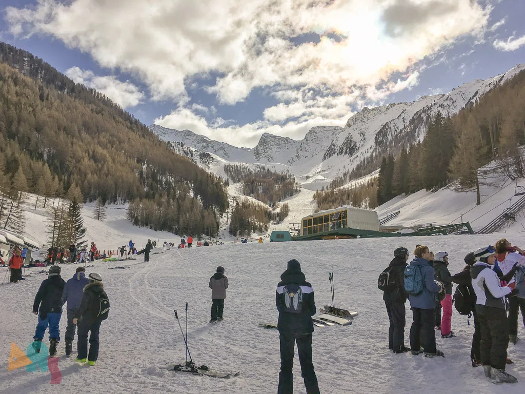 Skifahrende an der Talstation vor den Lärchen.